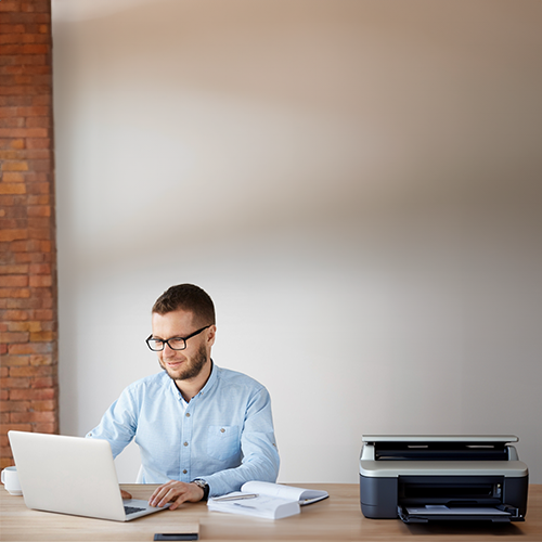 A Man Using a Laptop to Print Payroll Checks Free Online.