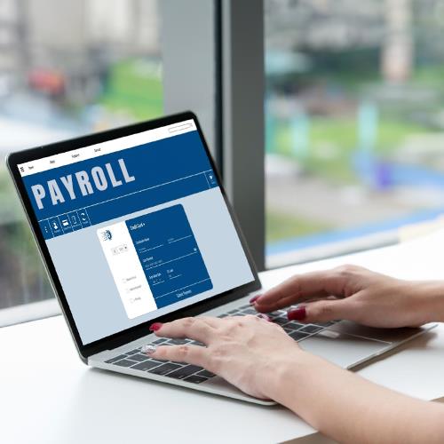 A Woman Typing on a Laptop with a Payroll Application Visible on the Screen, Showcasing One of the Best Payroll Services Small Businesses.