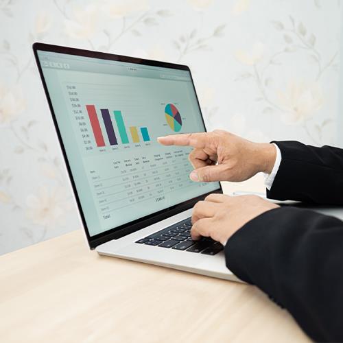 A Businessman Pointing at a Graph on a Laptop Screen, Showcasing Features of the Best Personal Budget App.