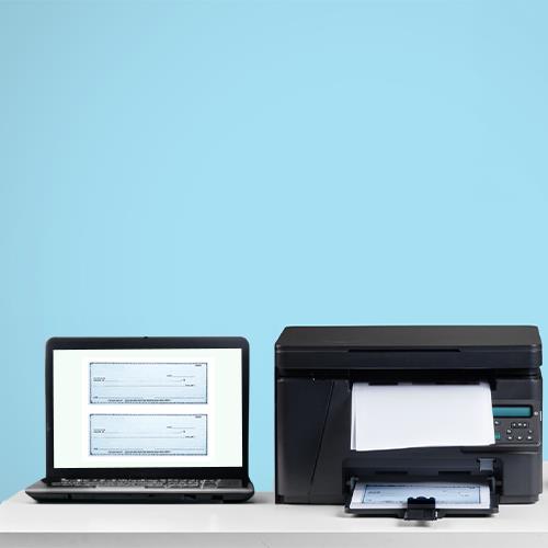 Printer and Laptop on a Desk, Symbolizing the Convenience of Creating Personal Bank Checks Online.