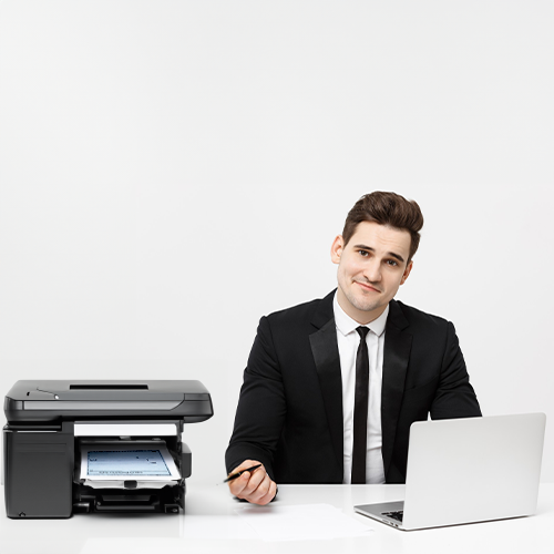 A Man in a Suit Sitting in a Chair with a Printer and Laptop. He Is Printing Checks Instead of Business Checks Order Online