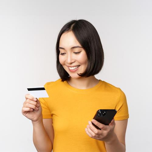 A Woman Holding a Credit Card and Smartphone, Illustrating the Process of How to Process Credit Card Payments Through Mobile Technology.