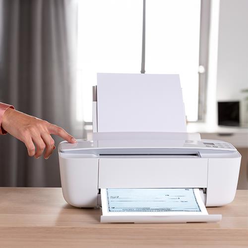 A Person Pointing at a Personal Checks Reorder Printer on a Table.