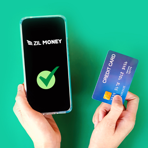A Person's Hand Holding a Smartphone with an Approval Screen, Alongside Another Hand Holding a Credit Card Payment Online Against a Green Background