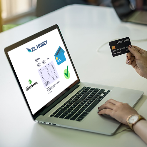 A Person Holding a Credit Card near a Laptop Displays the Credit Card Payment QuickBooks Interface, Showing Options for Payment Processing and Transaction Lists