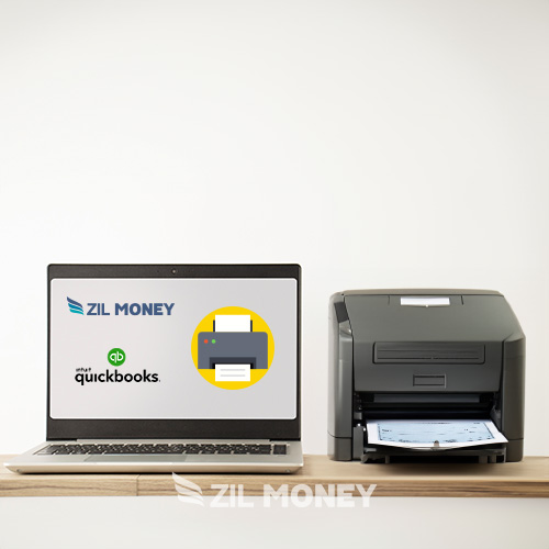 A Laptop on a Wooden Desk Displays QuickBooks Integration Logos Next to a Modern QuickBooks Check Printer, Set Against a Plain Background.