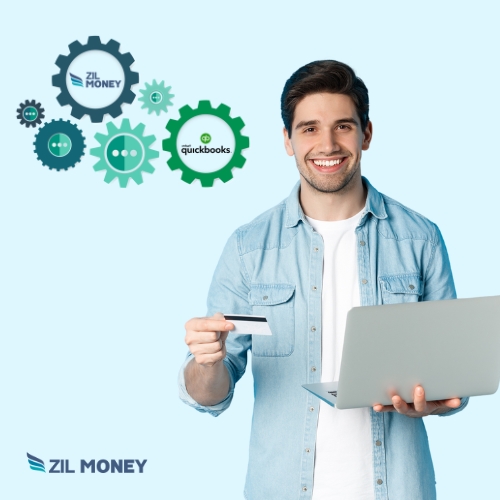 A Smiling Man Holding a Credit Card and a Laptop Represents Payroll by Credit Card QuickBooks for Faster Payments