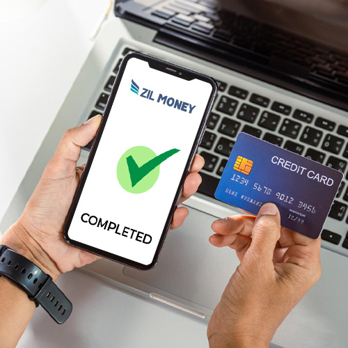 A Man Holds a Smartphone and a Credit Card, Ready to Send Money with Credit Card Online