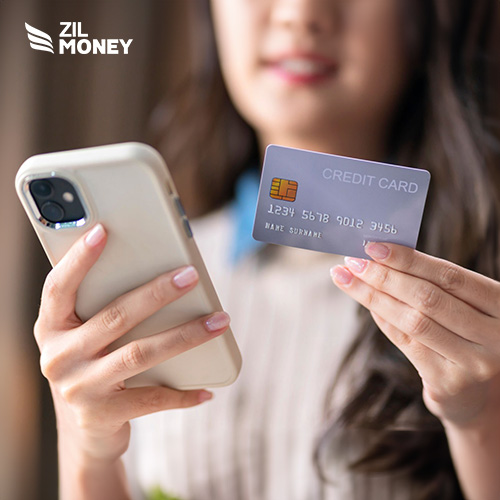 A Hand Holding a Credit Card And A Smartphone Accept Credit Card Payment. Secure and Versatile American Express Credit Card Payment Made Easy. Earn Rewards, Cashback