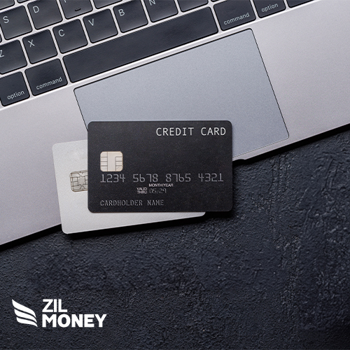 Two credit cards on a MacBook keyboard with Zil Money branding in the bottom left corner. it indicates Credit Cards For Benefits