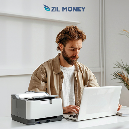 A man Using A Laptop And A regular Printer To Print Checks Save Time and Money with Check Printing Online Free