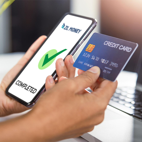 A Hand Holding Mobile Phone and Credit Card Making American Express Credit Card Payment