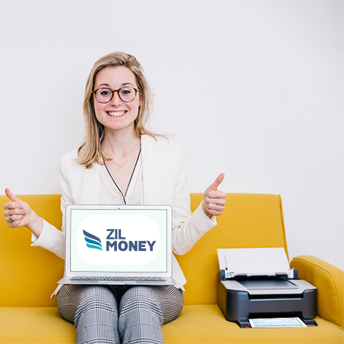 A Woman Is Holding a Laptop Displaying the Zil Money Logo, and a Printer Is Placed on the Couch Next to Her. Printing Checks Is Better Than Ordering Checks Online.