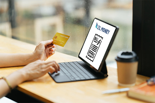 A Person Woring On A Laptop Paying Bills With Credit Card, Efficiently Pay Bills with Credit Cards for Your Wholesale Business