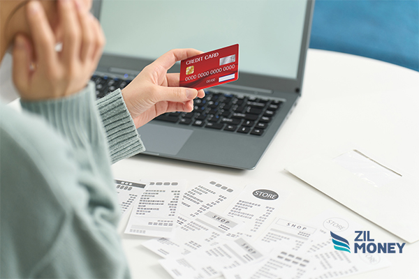 A Person Working On a Laptop, He Use Credit Cards To Pay Bills Effectively