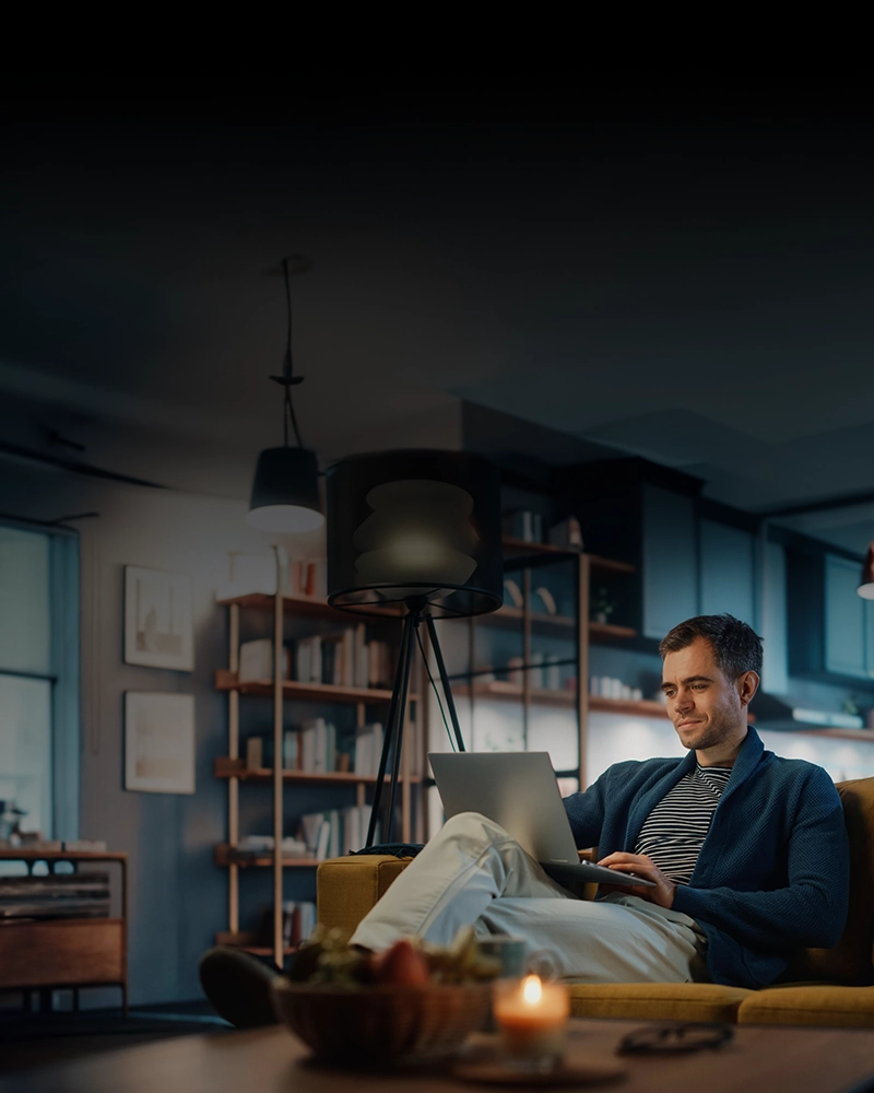 A Man Sitting And Holding a Laptop Using Accounting Software