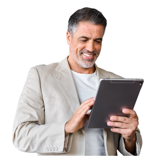 Design Professional Checks - a Smiling Man with Salt-And-Pepper Hair, Wearing a Light-Colored Blazer Over a White T-Shirt, Looking Down and Using a Tablet.
