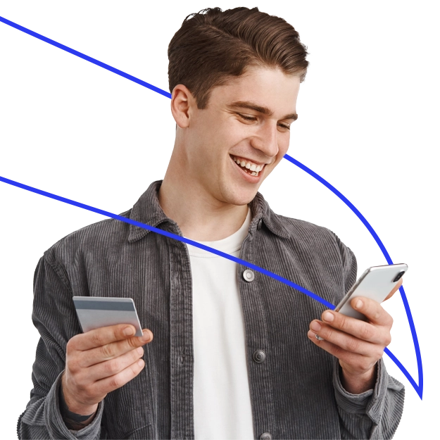 Pay with Credit Card – A smiling young man holds a credit card in one hand and a smartphone in the other, illustrating the convenience and ease of digital credit card payments.
