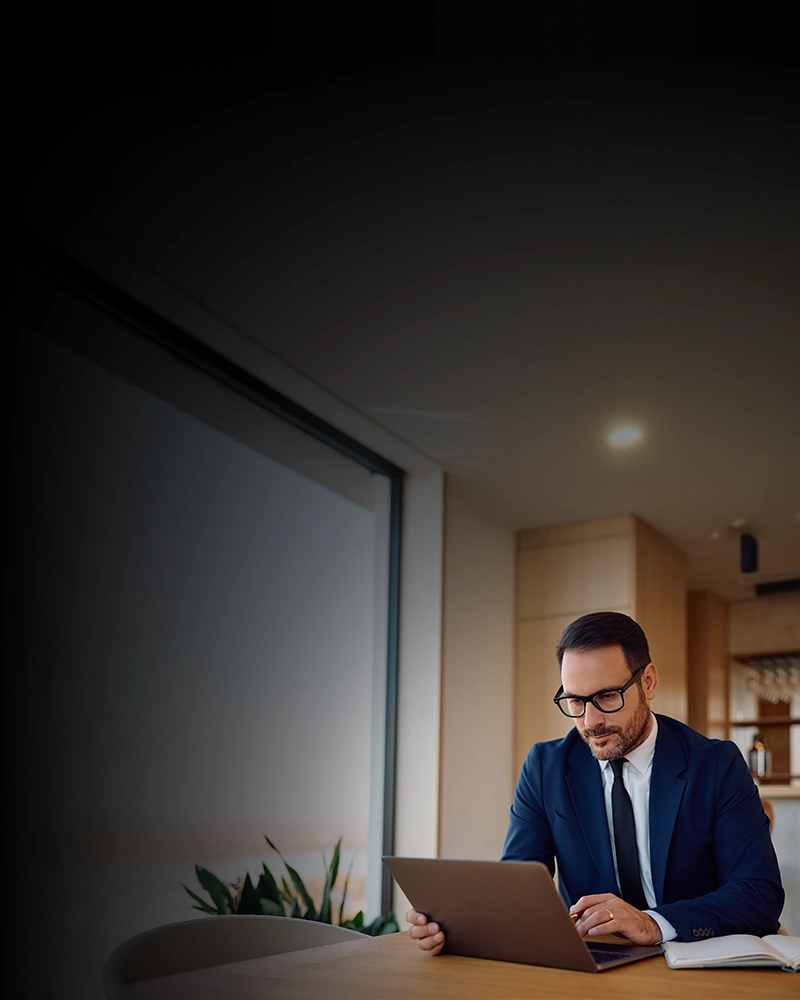 A businessman uses a laptop, representing the efficiency and convenience of making an Electronic Check Payment.