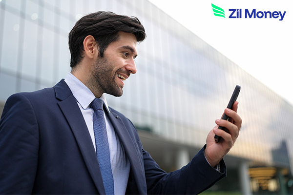 A business professional checks his phone outside an office, showing how ACH Payments support quick and secure business transfers.