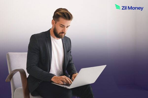 Business professional reviewing ACH Payments on a laptop, focused on reducing costs and improving cash flow.