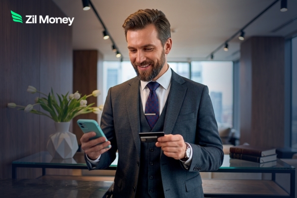A professional holds a bank card to pay vendors with credit card on a smartphone for better efficiency.