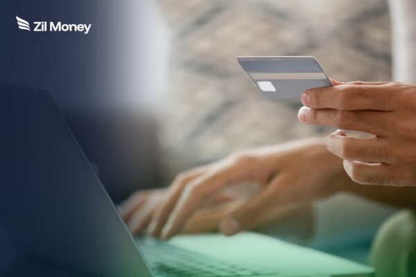 5 Ways a Vendor Payment Solution Using Credit Card Funding Fixes the Cash Flow Squeeze A close-up of a person typing on a laptop while holding a credit card, showcasing a vendor payment solution using credit card funding.