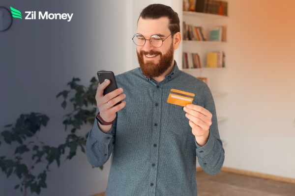 How Legacy Systems Create Payroll Gaps for Law and CPA Firms Smiling man with glasses holds a phone and card to manage payroll by credit card for better efficiency.