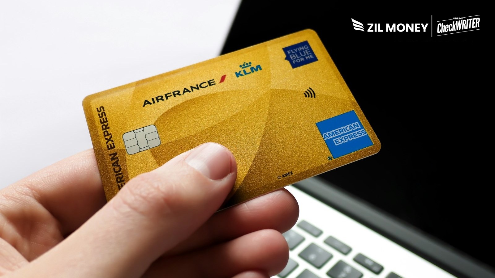 Pay business bills with an AmEx credit card on Zil Money Hand holding an American Express credit card near a laptop to pay business bills with Zil Money