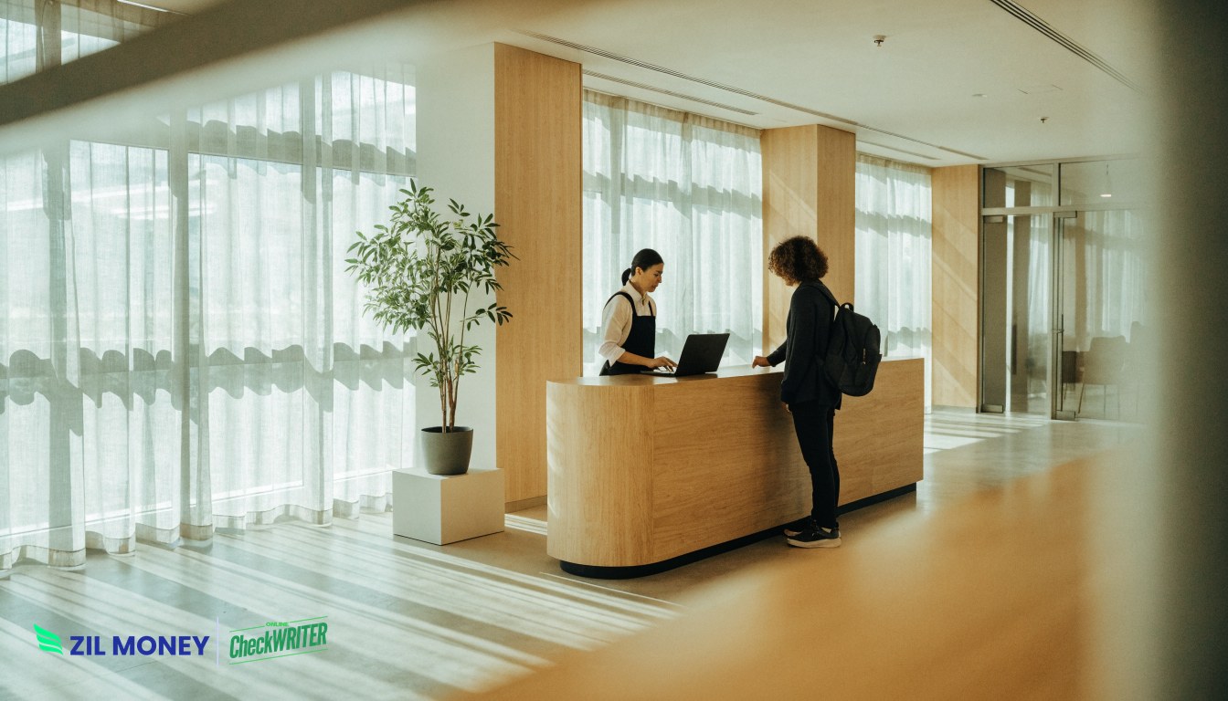 Club staff handling membership payments at a reception desk laptop