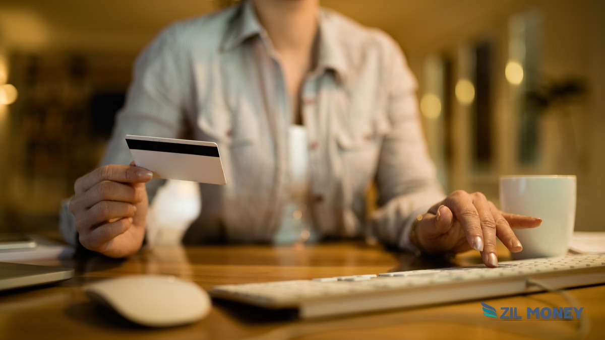 Amex Online Payment to a Vendor – Asheville Boutique Hotel Hero Business owner making an Amex online payment to a vendor from a laptop, Zil Money