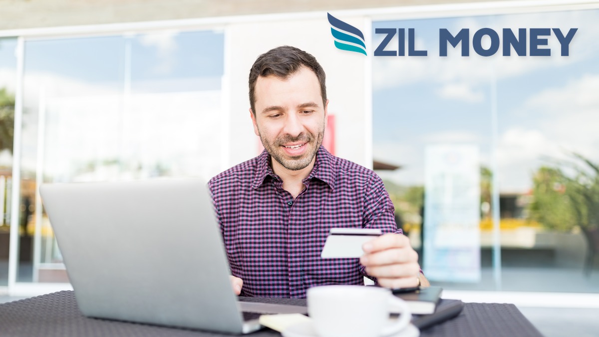 Business owner reviewing multiple bank accounts in one app on a laptop, Zil Money
