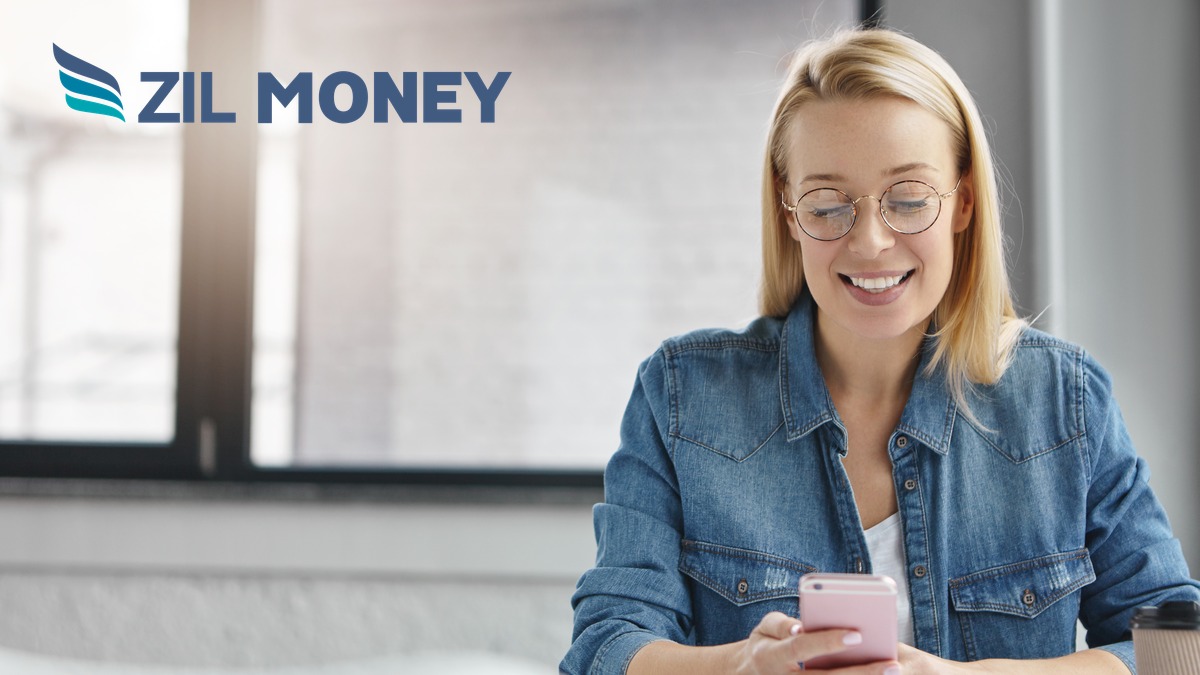 Business owner getting a payment notification on her phone, Zil Money logo